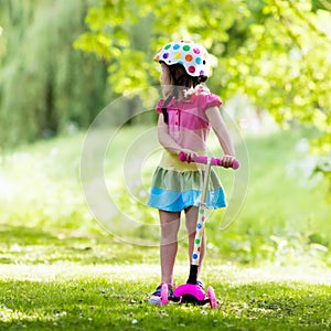 Little girl riding a colorful scooter