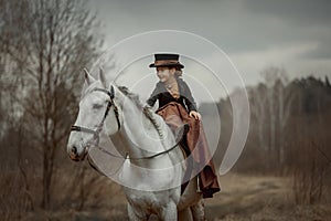 Little girl in riding habit with horse and vizsla