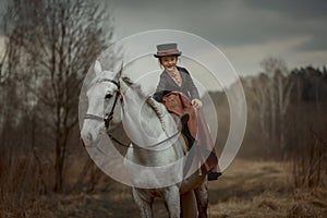 Little girl in riding habit with horse and vizsla