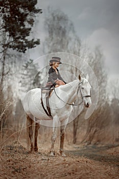 Little girl in riding habit with horse and vizsla