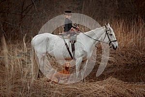 Little girl in riding habit with horse and vizsla