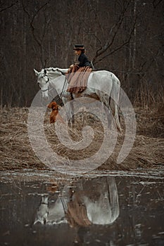 Little girl in riding habit with horse and vizsla