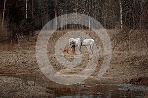 Little girl in riding habit with horse and vizsla