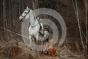 Little girl in riding habit with horse and vizsla photo