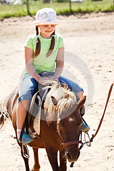 Little girl riding pony