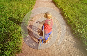 Little girl riding runbike in summer