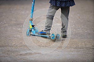 Little girl riding scooter outdoors, active sport kids