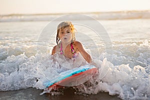 Little girl riding wave on boogie board