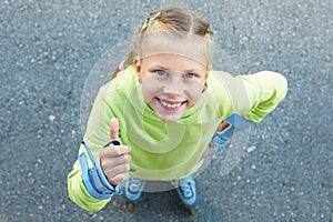 Little girl on roller skates in park. Happy girl.