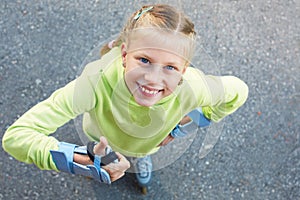 Little girl on roller skates in park. Happy girl.