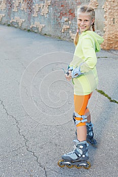 Little girl on roller skates in park. Happy girl.