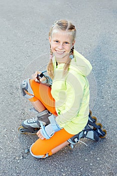 Little girl on roller skates in park. Happy girl