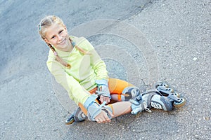 Little girl on roller skates in park. Happy girl