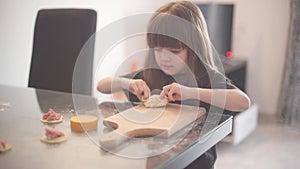 Little girl rolls out dough and helps her mother