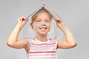 Little girl with roof of book on top of her head