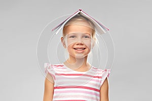 Little girl with roof of book on top of her head