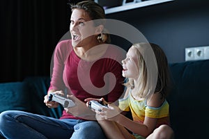 Little girl with her mother play video games, close-up