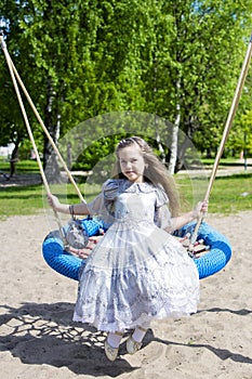 Little girl on the round swings posing