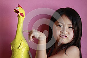 Little girl with rubber chicken