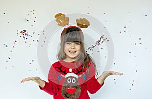 Little girl in rudolf hat waiting for a Christmas on white background.