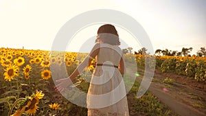 Little girl running across the field with sunflowers at sunset. slow motion video. girl runner in the field lifestyle at