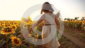 Little girl running across the field with sunflowers at sunset. slow motion video. girl runner in the field at lifestyle