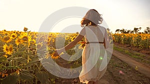 Little girl running across the field with sunflowers at sunset. slow motion video. girl runner in the field at sunset