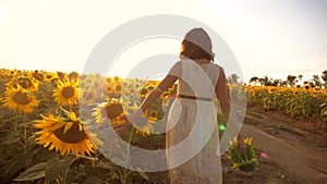 Little girl running across the field with sunflowers at sunset. slow motion video. girl runner in the field at sunset