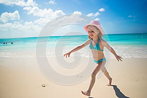 Little girl running along the beach and enjoy summer holidays