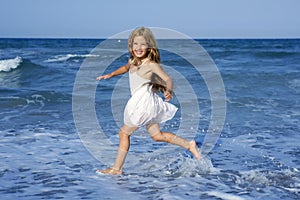 Little girl running beach in blue sea