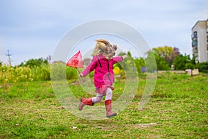 A little girl is running with butterfly net having fun