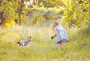 Little girl running with the dog in the countryside