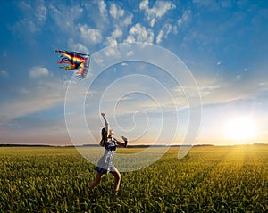 Little girl running on field with kite