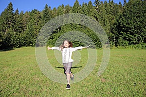 Little girl running on green grass field