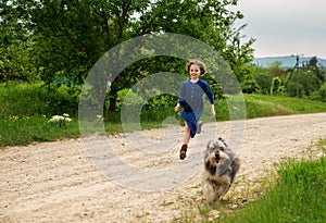 Little girl running with her dog outdoors in rural areas in summer