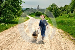 Little girl running with her dog outdoors in rural areas in summer