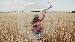 little girl running with a kite. happy family kid dream concept. a child plays in the park runs with a kite in a field