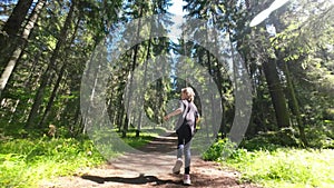 Little girl runs along a forest path in summer. Slow motion