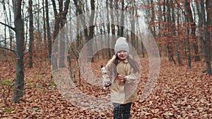 Little girl runs through the autumn forest