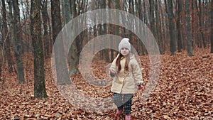 Little girl runs through the autumn forest