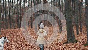 Little girl runs through the autumn forest