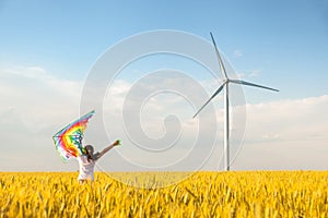 Little girl runs in a wheat field with a kite