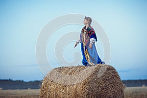 Little girl in Russian costume in the field