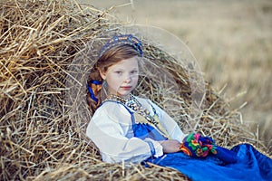 Little girl in Russian costume in the field