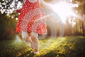 Little girl`s bare feet in the grass. little girl running