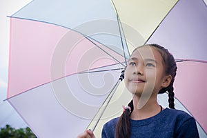 Little girl`s hold umbrella smile and looking at on the rainy season