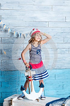 Little girl sailor standing and keeps anchor