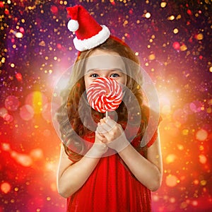 Little girl in santa hat with candy cane. Christmas time