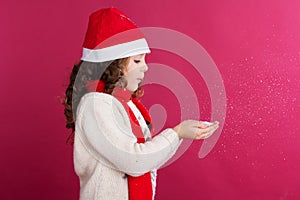 Little girl in santa hat is holding fake snow