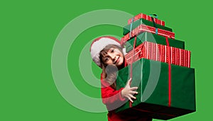 A little girl in a Santa hat is holding a lot of gift boxes. New Year& x27;s gifts for Christmas. 2023. Isolated on a